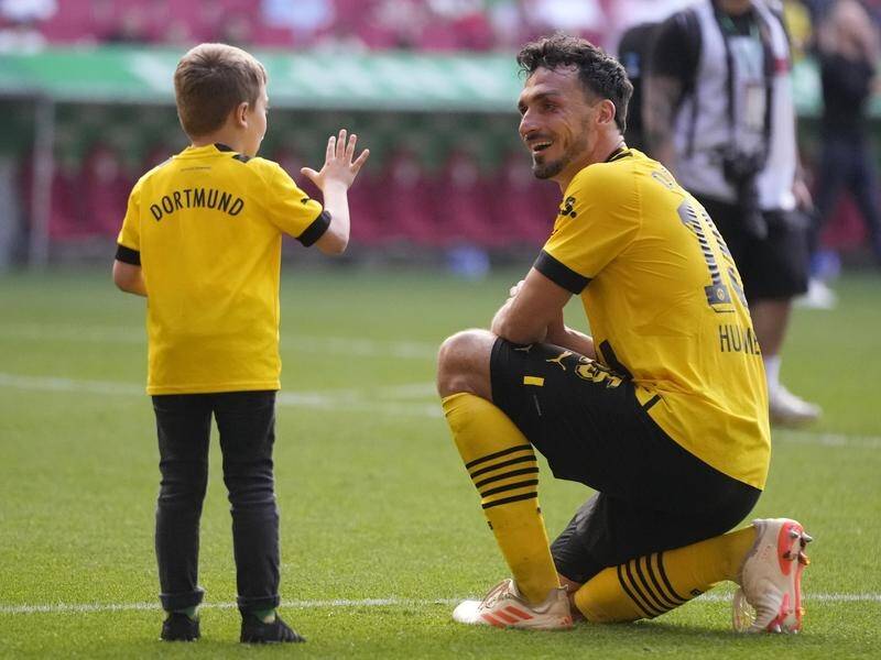 Mats Hummels celebrates with his son after Dortmund moved cloer to the German title at Augsburg. (AP PHOTO)