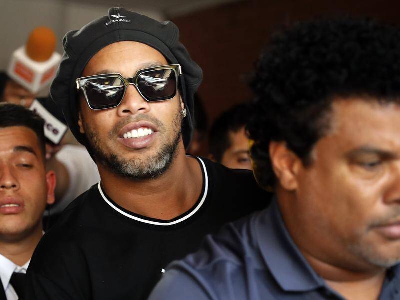 Ex-soccer star Ronaldinho (c) has been detained for entering Paraguay with a falsified passport.