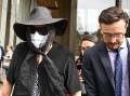 Former teacher Gaye Grant arrived in court wearing a black hat, sunglasses, veil and face mask. (Dan Himbrechts/AAP PHOTOS)