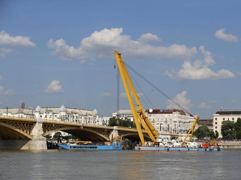 A floating crane is being used to raise a tour boat which sank on the Danube River last month.