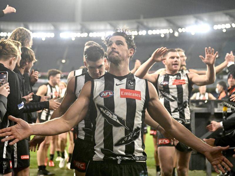 Collingwood players walk off the MCG after a bumper crowd watched their thrilling win over Carlton.