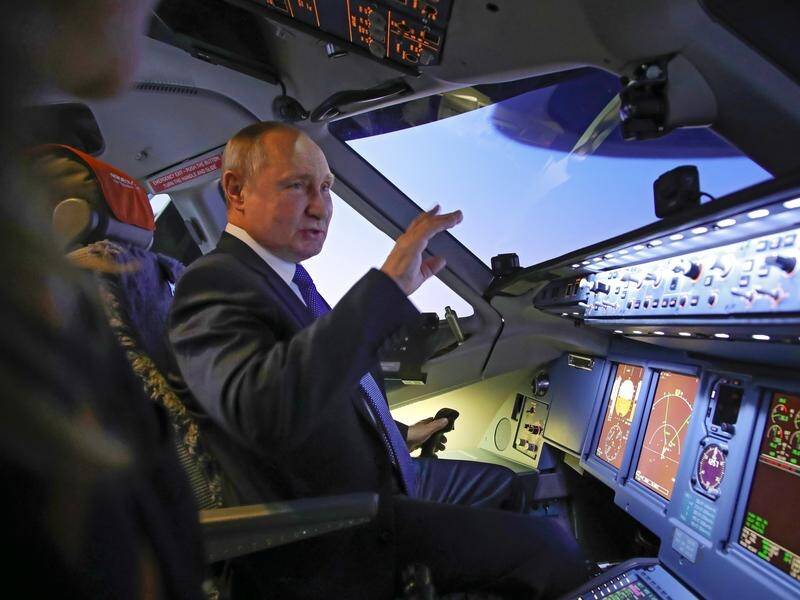 Russian President Vladimir Putin has sat in an airplane simulator at the Aeroflot Aviation School.