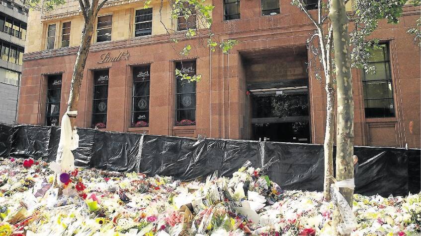 Tributes outside the Lindt Cafe in Sydney's Martin Place following the fatal siege in 2014. Picture by Getty Images.