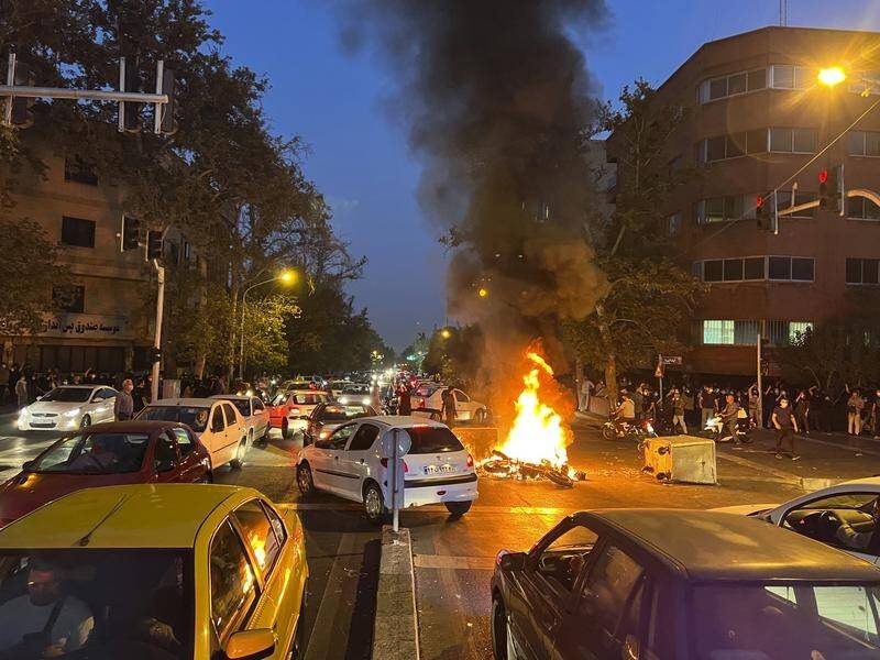 Protesters have set cars and bins on fire in Iran amid unrest over the death of a woman in custody. (AP PHOTO)