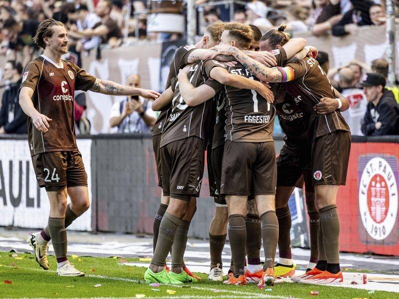 No.24 Connor Metcalfe joins Jackson Irvine (R) in the huddle after St Pauli's third sealing goal. (AP PHOTO)