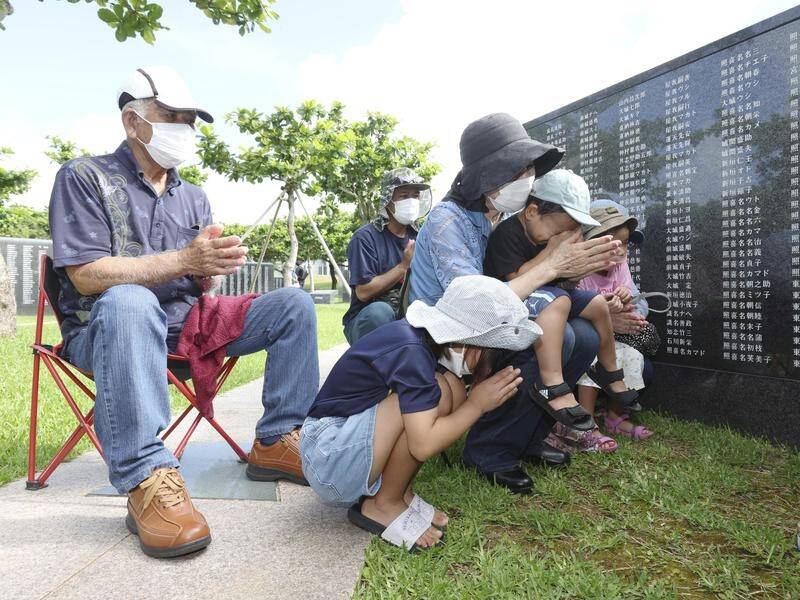 A family pays tribute to war victims at the Okinawa Peace Memorial Park in Itoman City, Okinawa.