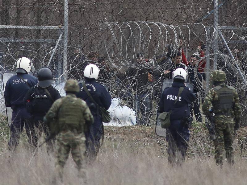 Greek police have fired tear gas and stun grenades at migrants trying to cross the Turkish border.