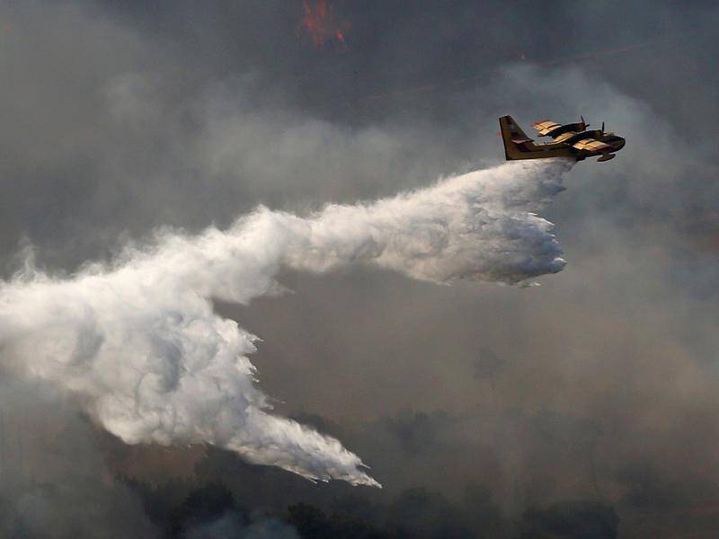 Water-dropping planes and helicopters have been involved in the firefighting effort near Athens.