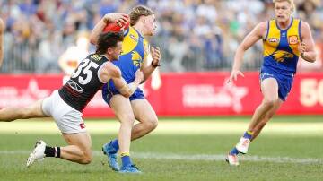 West Coast's Harley Reid (centre) was caught in a strong tackle by St Kilda's Jack Sinclair. (David Woodley/AAP PHOTOS)