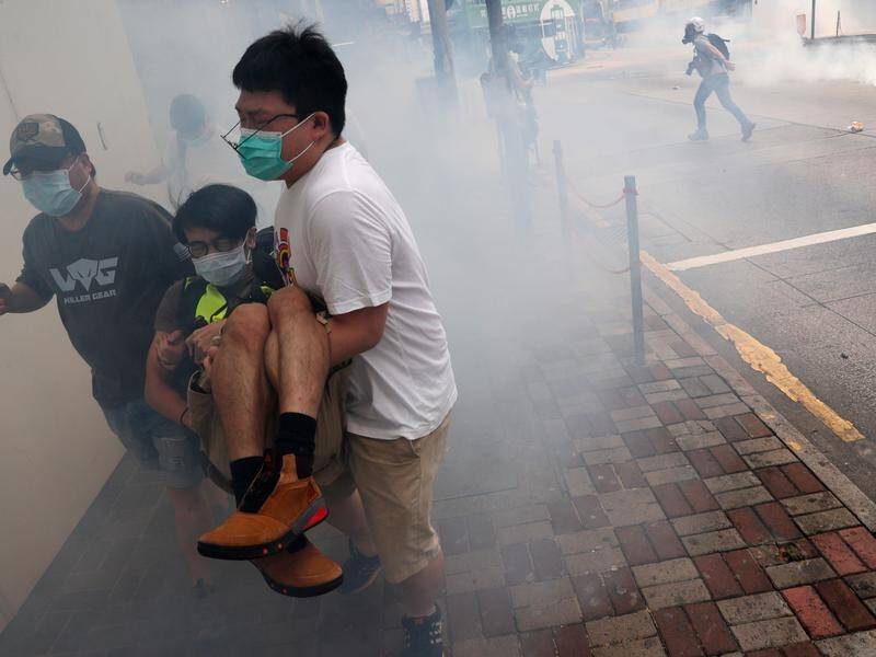 Protesters in Hong Kong run from tear gas during a march against proposed new security laws.