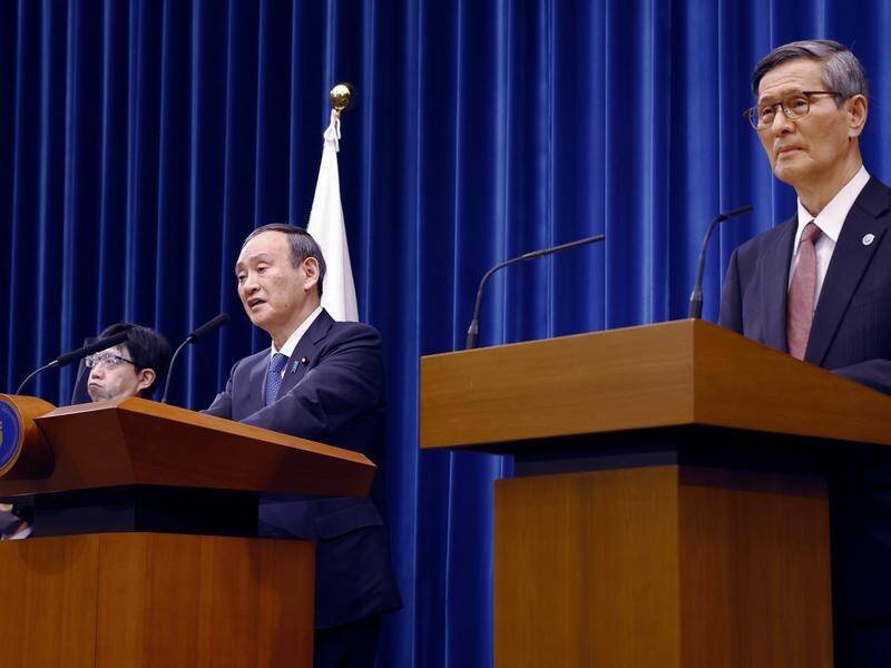 Japan's PM Yoshihide Suga (left) announcing Olympic host city Tokyo's new state of emergency.