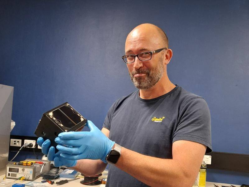 Curtin University's Phil Bland holding the Binar-1 Cubesat satellite, the first WA-built spacecraft.