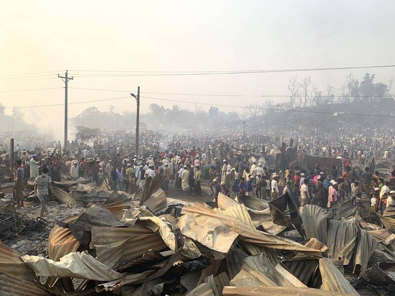 Officials are investigating the cause of the refugee camp blaze as the search continues for victims.