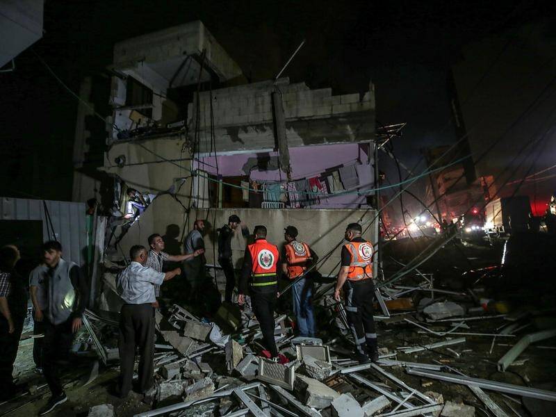 Rescuers search for survivors in the rubble of a destroyed house in Gaza City.