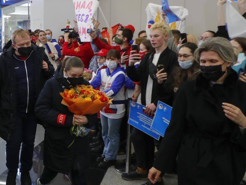 Supporters welcome Kamila Valieva (centre) and her coach Eteri Tutberidze (right) back to Moscow.