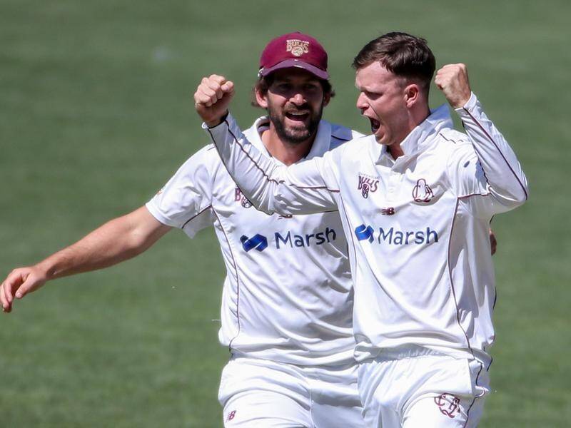 Queensland's Matthew Kuhnemann (r) has claimed his first five-wicket haul in the Sheffield Shield.