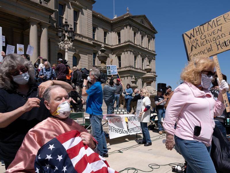 Anti-lockdown protesters stage a haircut rally outside the Capitol building in Lansing, Michigan.