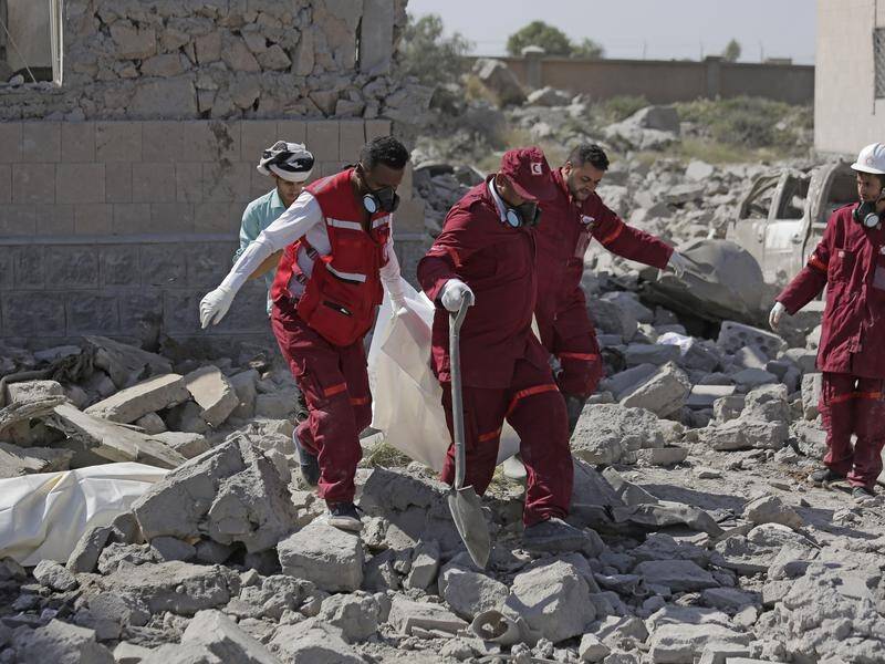 Rescue workers carry a body from a Houthi detention centre hit by Saudi-led air strikes.