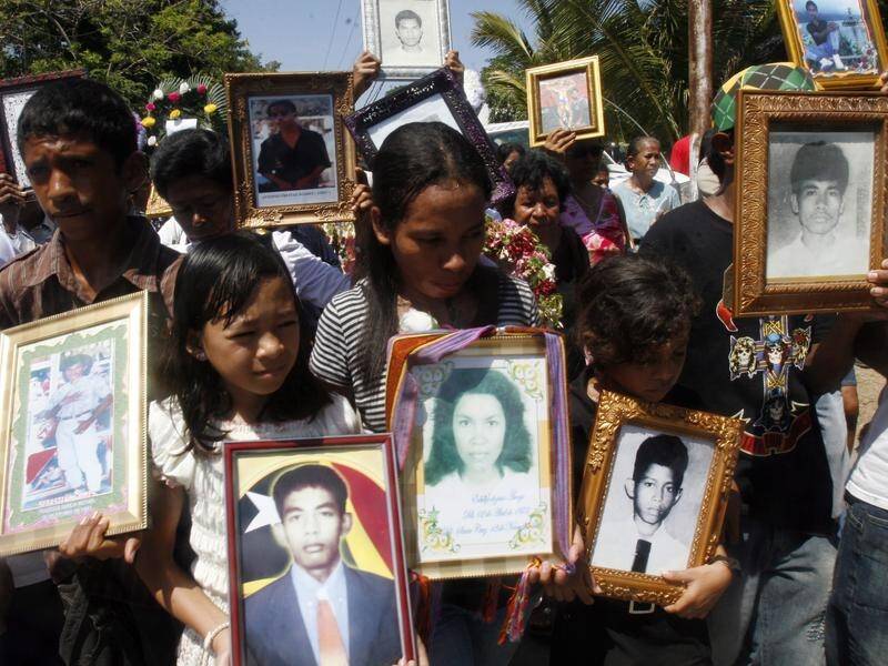Relatives hold photos of Santa Cruz massacre victims at a commemoration in East Timor in 2009.