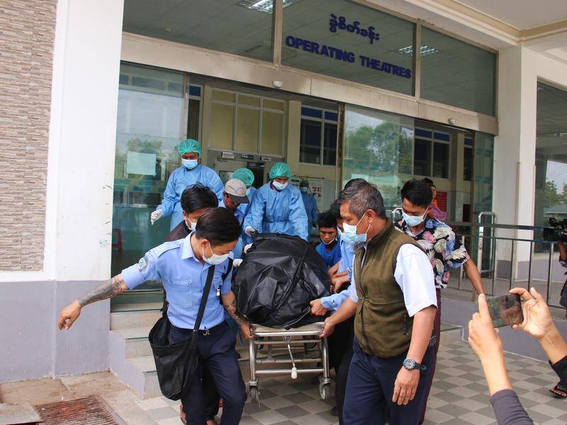 Hospital staff carry the body of the woman shot in the head during anti-coup protests in Myanmar.