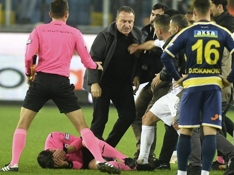 Referee Halil Umut Meler holds his face after being punched by Ankaragucu boss Faruk Koca (c). (AP PHOTO)