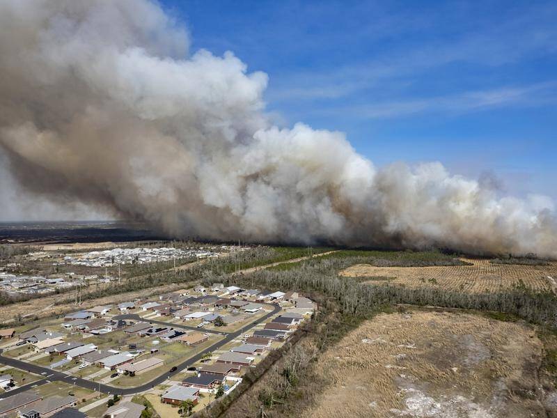 Firefighters are working to protect homes from large wildfires across Florida's panhandle.