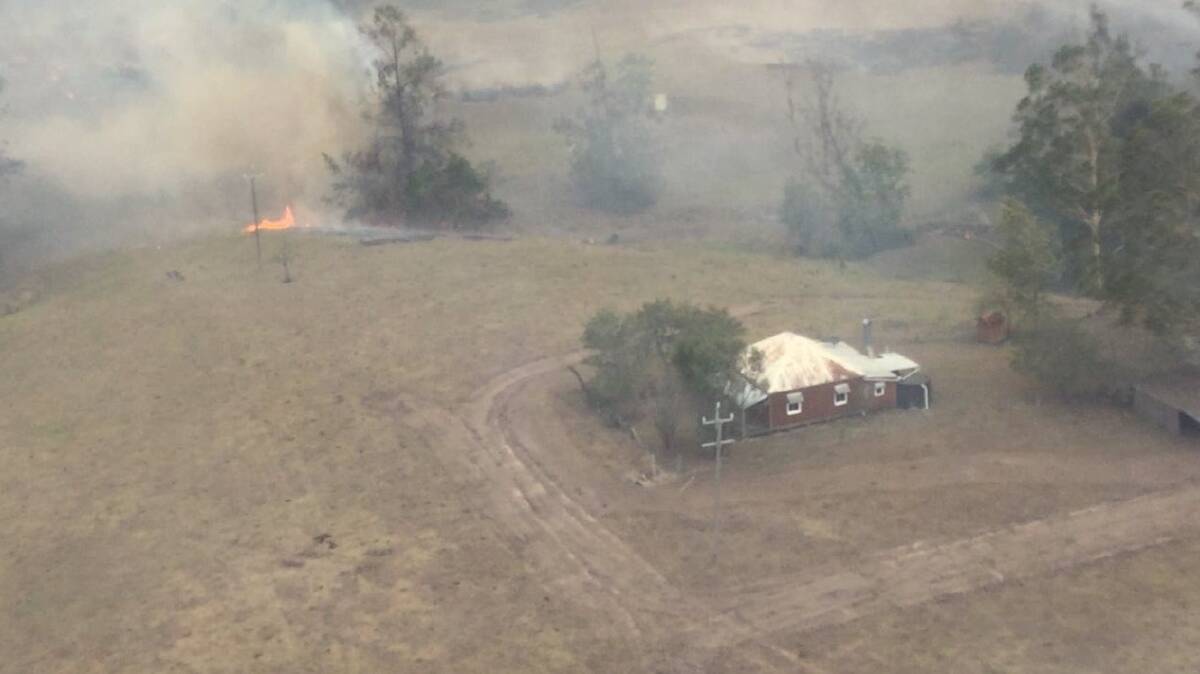 It took a concentrated effort from landholders, the Rural Fire Service, Nation Parks and Wildlife Services and Fire and Rescue NSW to save the cottage. Photo: Air Observer 