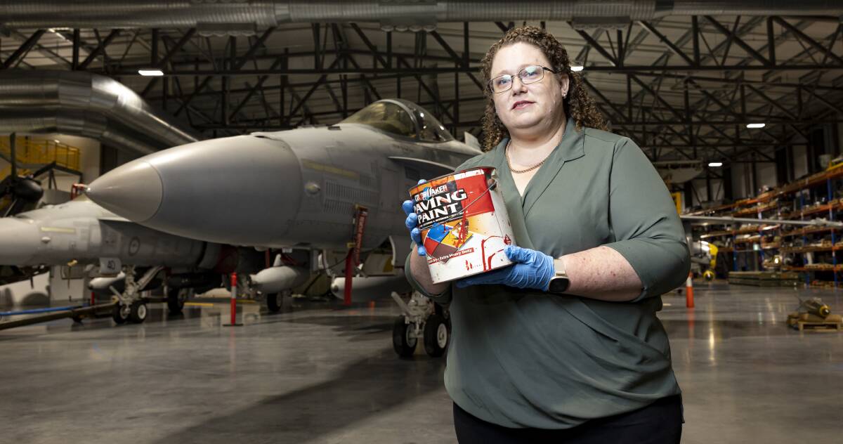 AWM curator Kerry Neale holds a tin of red paint used to paint 'No War' on the Opera House. Picture by Keegan Carroll