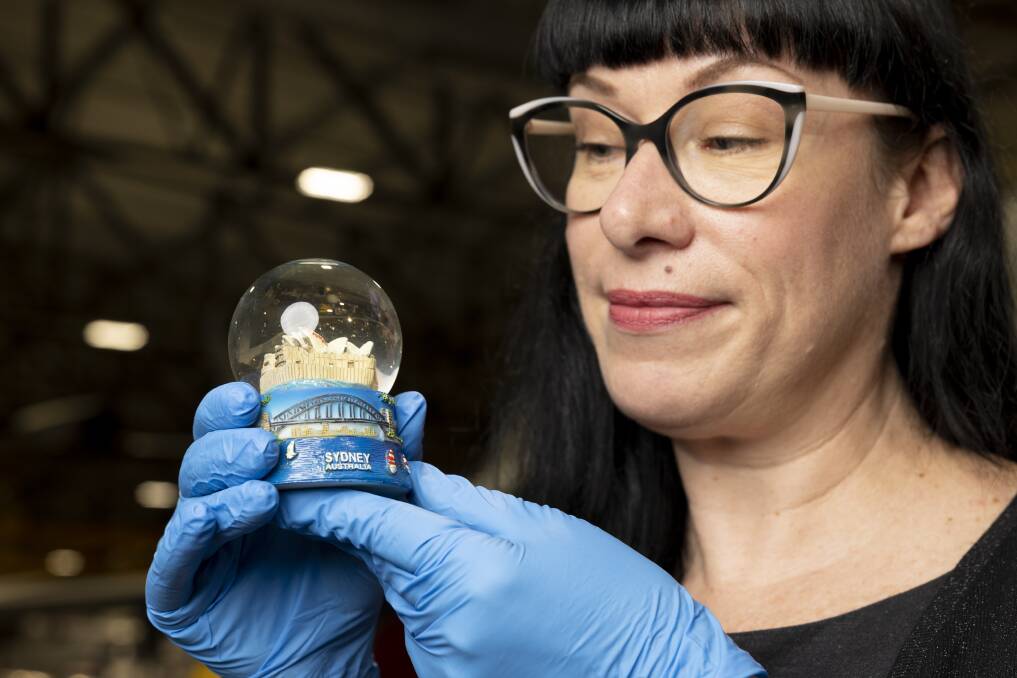 Curator Bliss Jensen with the anti-war snow globe showing No War on an Opera House sail. Picture by Keegan Carroll