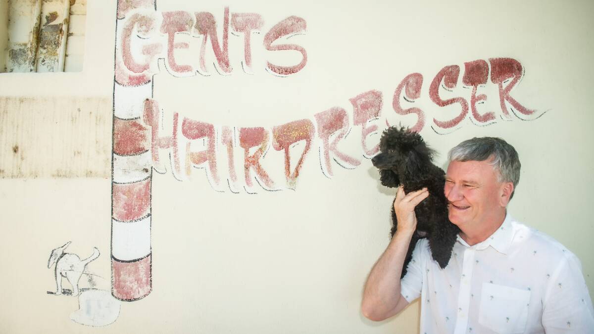 O'Connor post office licensee Ken Waring with canine friend Buddy and the mural. Picture by Karleen Minney