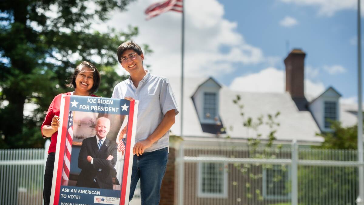Ritu Clementi and her son, Nikhil, of Democrats Abroad, celebrate the incoming President Biden outside the American embassy in Canberra. Picture: Karleen Minney