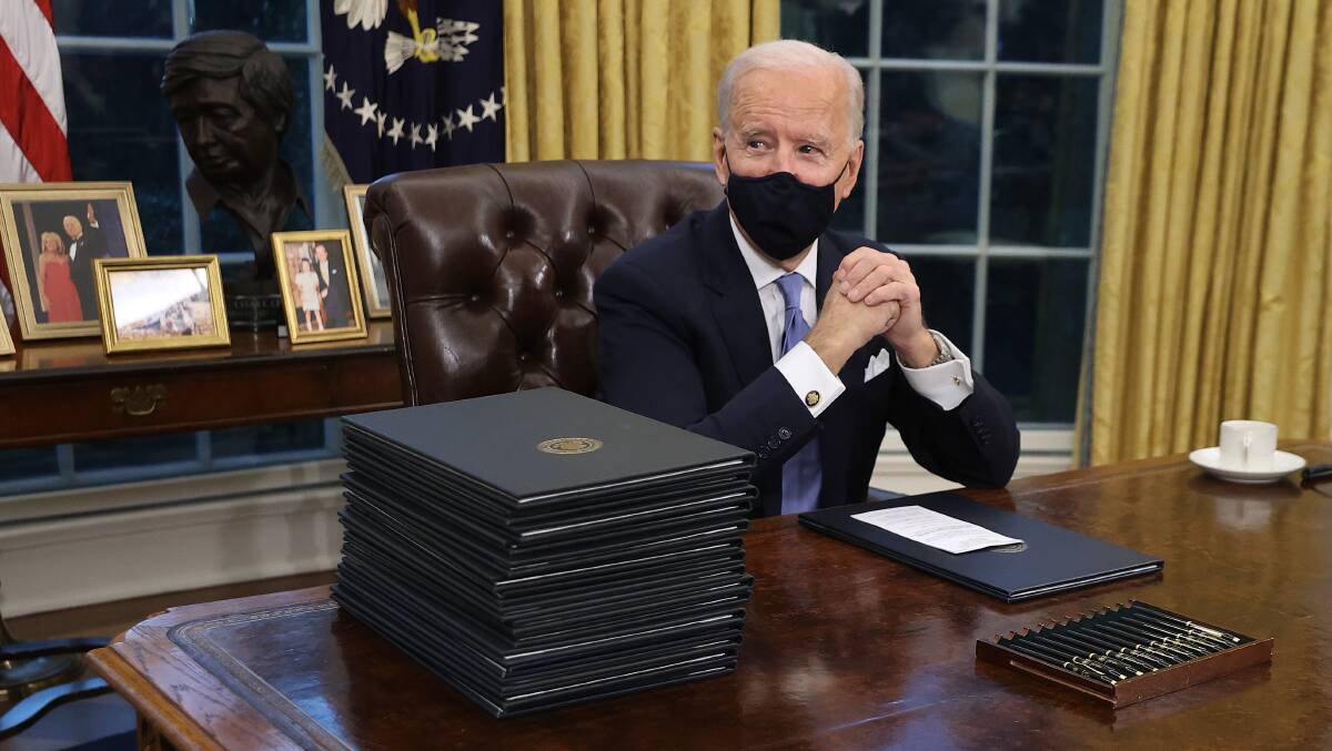 US President Joe Biden prepares to sign a series of executive orders in the Oval Office just hours after his inauguration. Picture: Getty Images