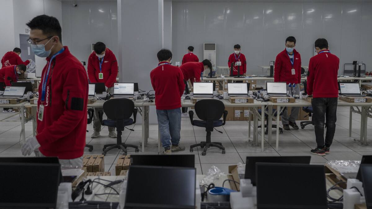 Workers prepare laptops that will be used at venues during an organised media tour of the Beijing Winter Olympics on December 9. Picture: Getty Images