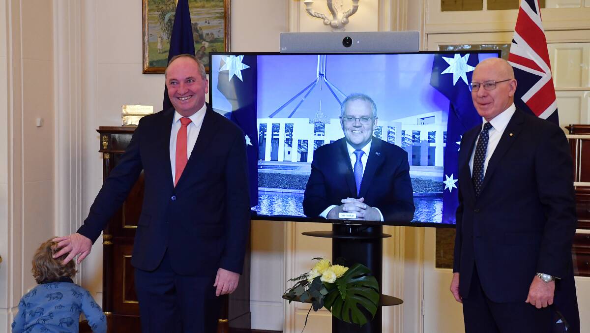 Deputy Prime Minister Barnaby Joyce (left) poses after his swearing-in ceremony as Prime Minister Scott Morrison watches on from quarantine. Picture: Getty Images