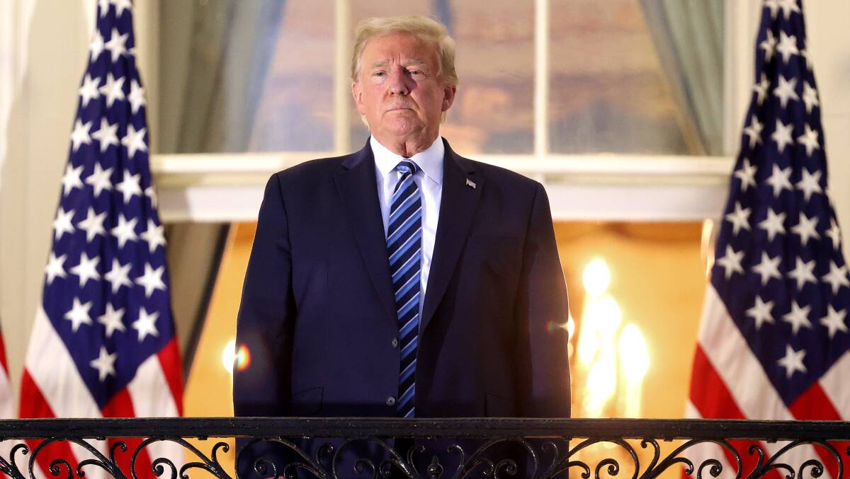 US President Donald Trump stands on the Truman Balcony after returning to the White House from Walter Reed National Military Medical Center. Picture: Getty Images