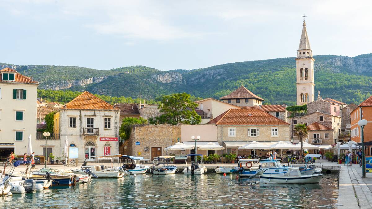 Small towns dot the coast of Hvar island, with fishing boats moored in the harbours.