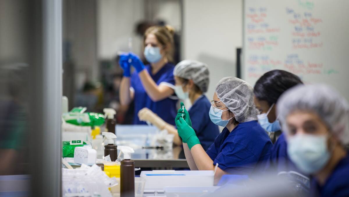 Staff prepare vaccine doses at Melbourne Exhibition Centre mass vaccination hub. Picture: Getty Images