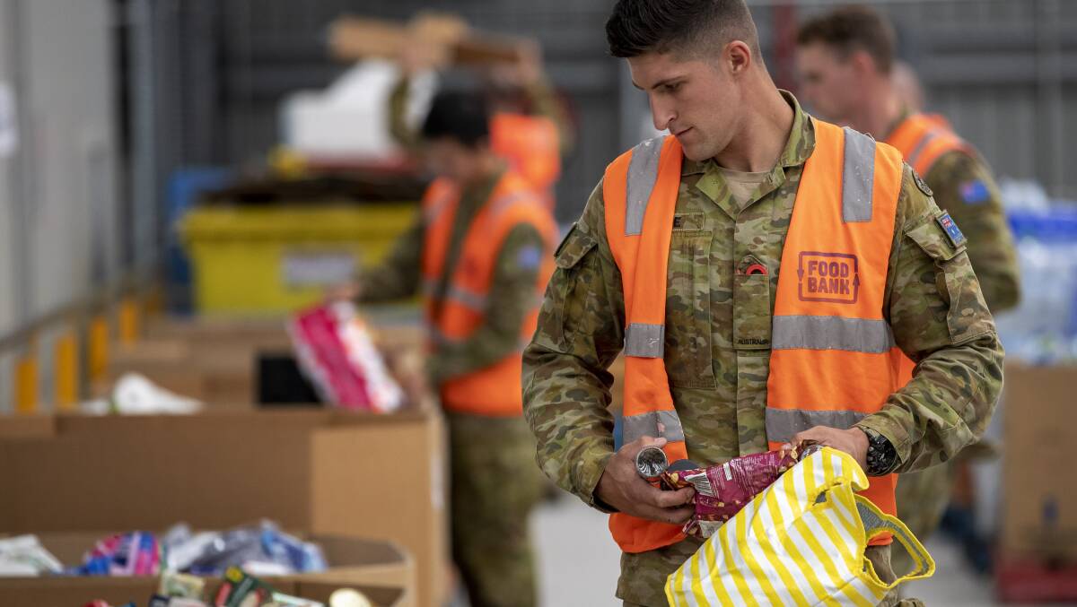 An Australian Army soldier sorts donations at a foodbank warehouse as part of Defence support for the governments COVID-19 response. Picture: Department of Defence
