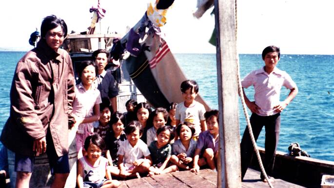 Huy Truong, then 7, arrives with other refugees on a fishing boat from Vietnam in 1978. He is the child in the purple shirt, closest to the mast. Picture: Supplied