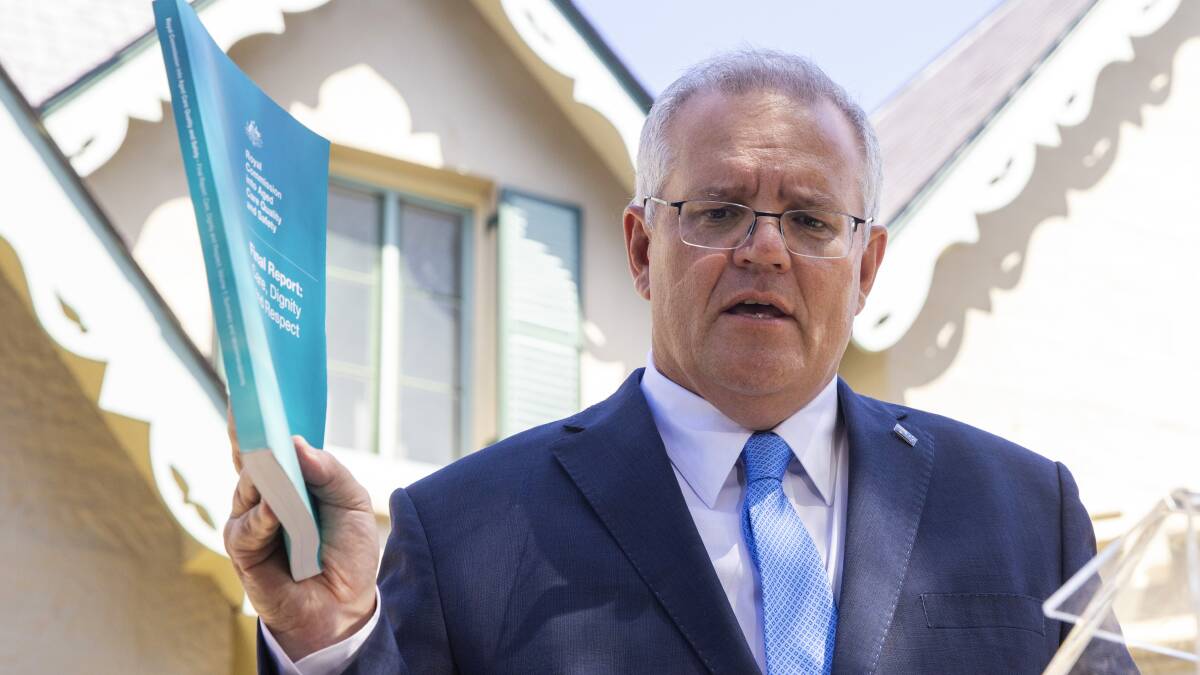 Prime Minister Scott Morrison holds the aged care royal commission's final report. Picture: Getty Images