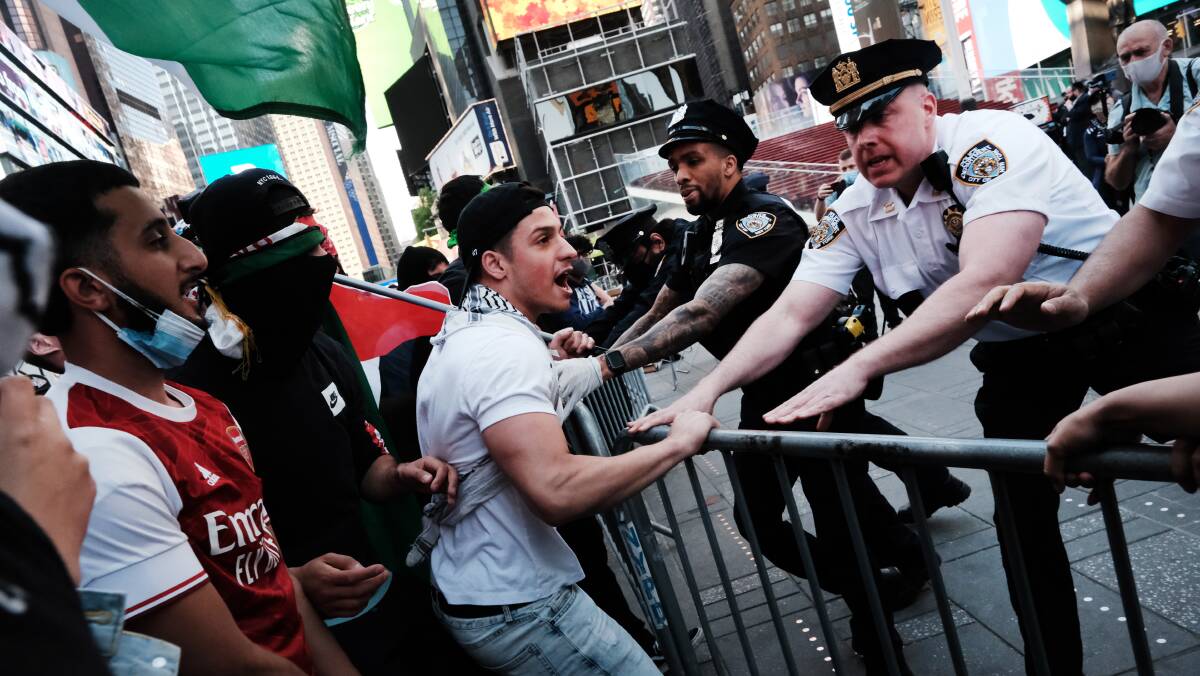 Pro-Palestinian protesters face off with a group of Israel supporters and police in Times Square on Thursday. Picture: Getty Images