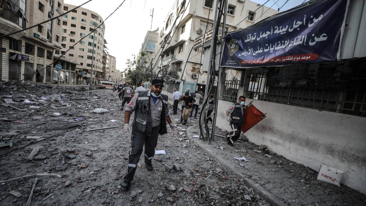 Civil defence team members carry out a search and rescue mission after Israeli warplanes struck the headquarters of the Qatari Red Crescent Society in Gaza City on May 17. Picture: Getty Images
