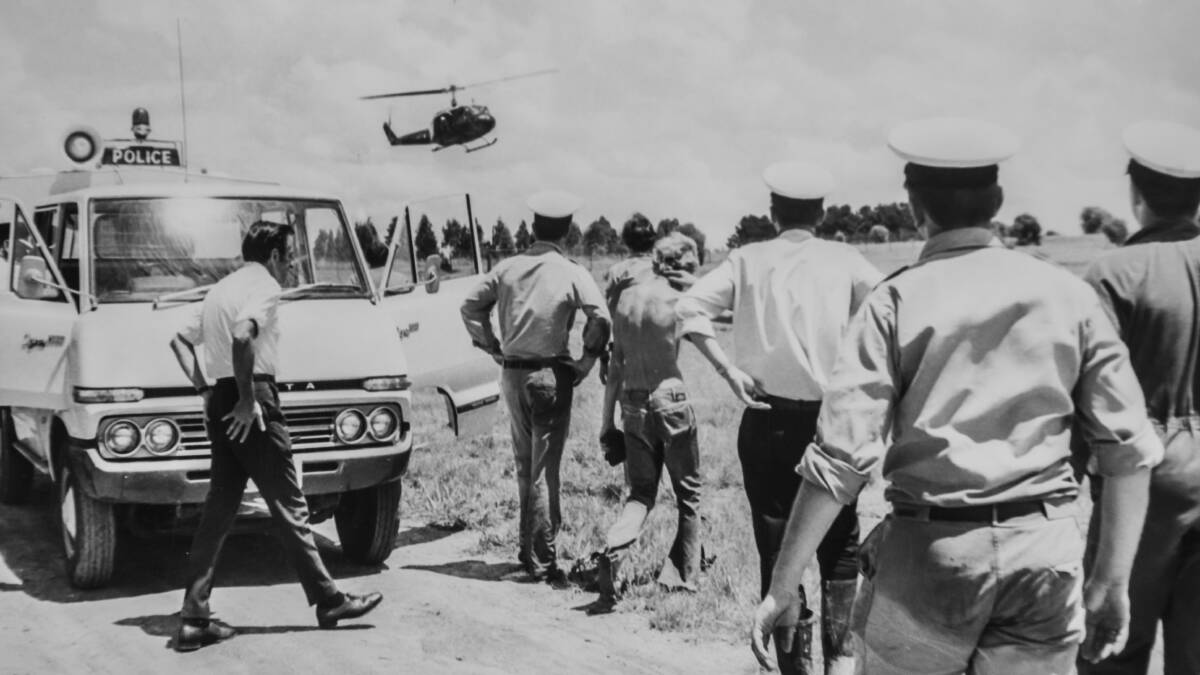 An RAAF helicopter returns to the Yarralumla Woolshed with one of the victims of the flood. The body was recovered from the Molonglo River about a mile downstream from the Scrivener Dam. Picture: Canberra Times archives