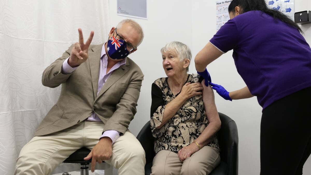 Prime Minister Scott Morrison gives the V for victory sign as Jane Malysiak, 84, receives Australia's first COVID-19 vaccination. Picture: Getty Images