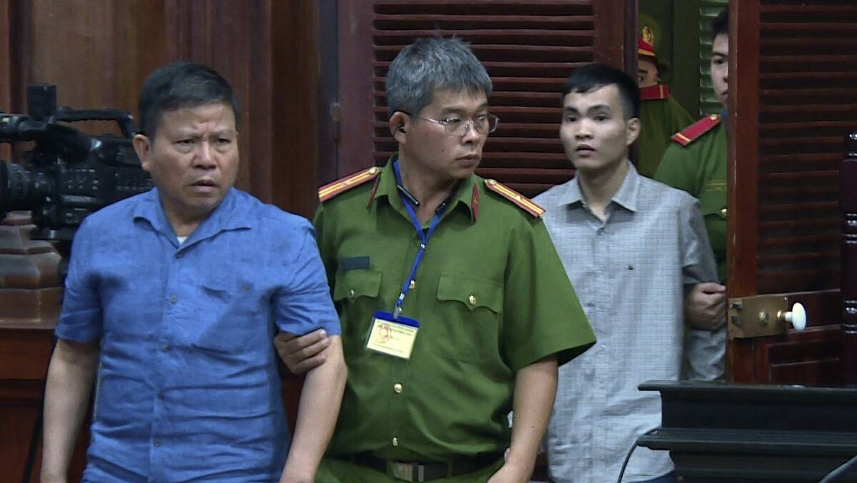 Chau Van Kham, left, is escorted into a court room in November. Picture: AP/VNA