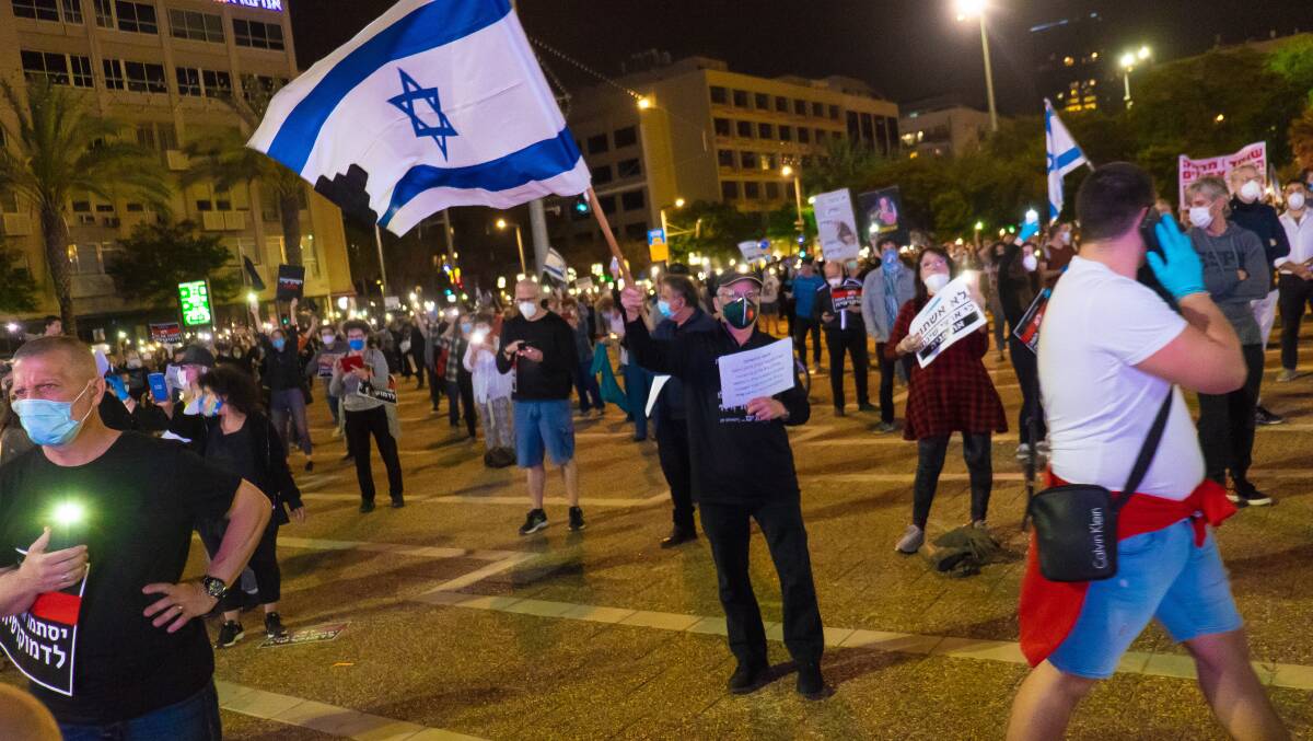 Israelis in Tel Aviv demonstrate against Prime Minister Benjamin Netanyahu due to his upcoming trial for corruption while keeping two metres apart. Picture: Getty Images