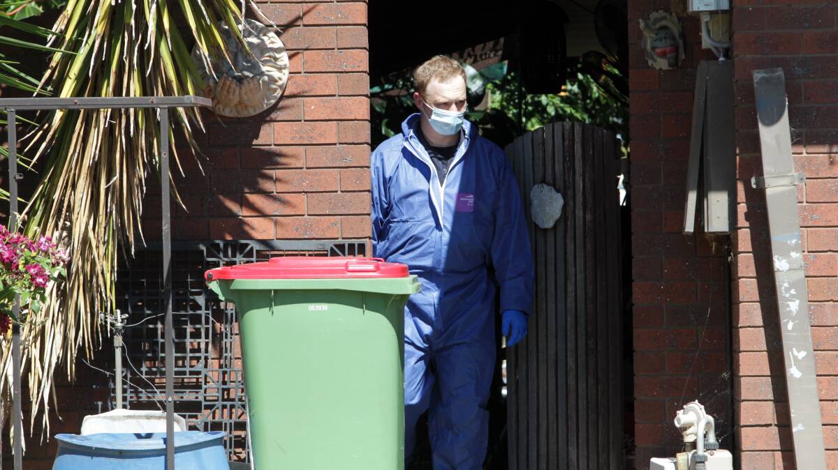 A forensic police investigator at the property after it was declared a crime scene. 