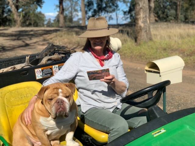 Susie Watson of East Gippsland with one of the Australia Post postcards being delivered to rural and remote households to help people stay connected. Picture: supplied.
