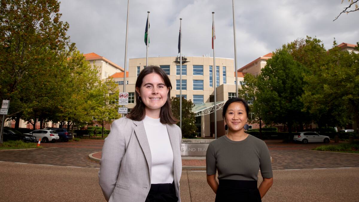 2020 DFAT graduate Amelia Ekkel and 2021 graduate Su-Yin Lew in front of the department's Barton building. Picture: Sitthixay Ditthavong