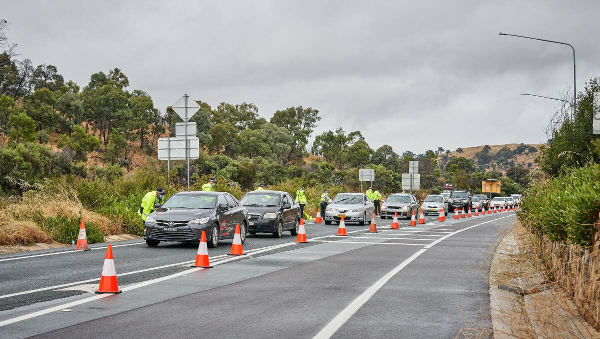 Cars line up along Federal Highway waiting to pass police checkpoints into the ACT. Picture: Matt Loxton